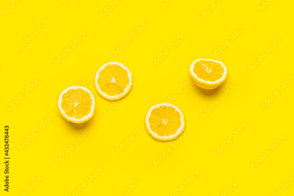 Fototapeta lemon wedges and sliced lemon on a yellow background. Top view, flat lay.