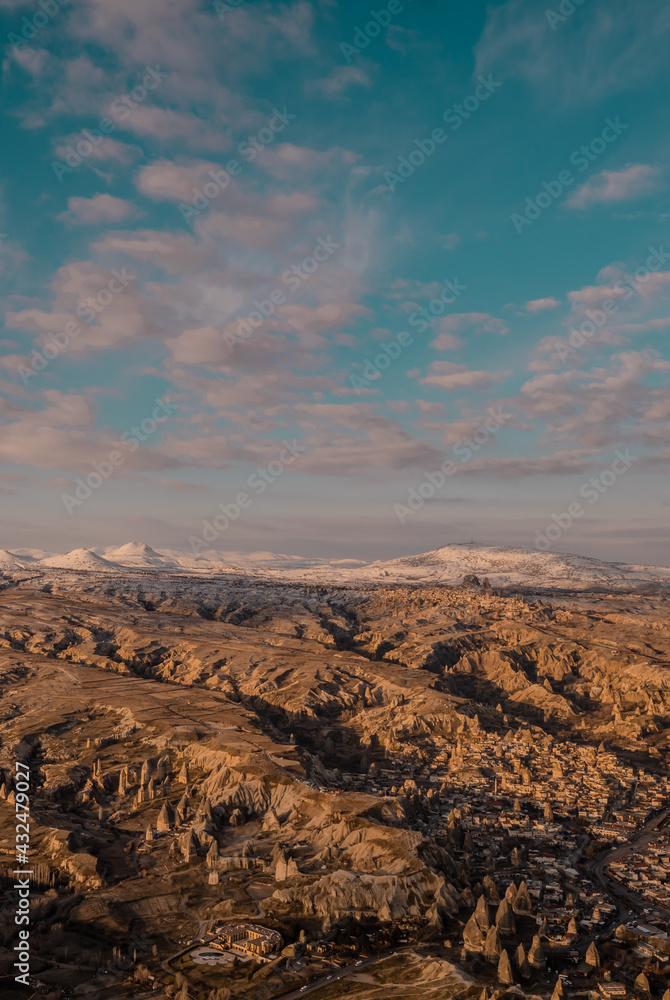 Beautiful vertical aerial view of the landscapes of Cappadocia, Turkey with fairy chimneys, mountains, rock formations and the town of Ürgüp