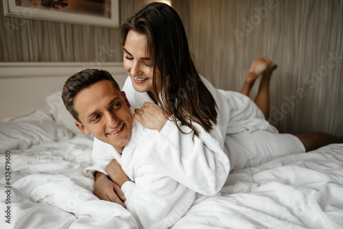 A couple in love lying on a bed in bathrobes