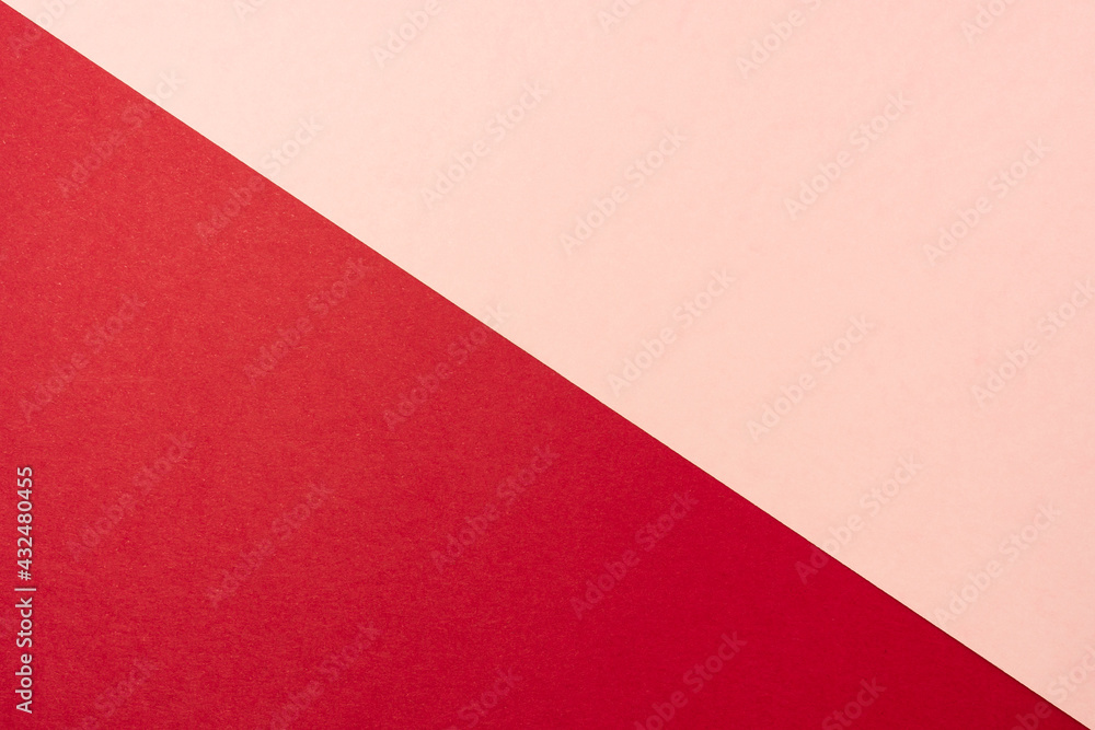 Background of two colors. Red and pink paper sheets divided diagonally.