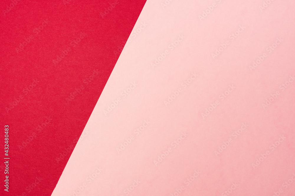 Colored paper background. Red and pink paper sheets split on two unequal parts by sloping border.