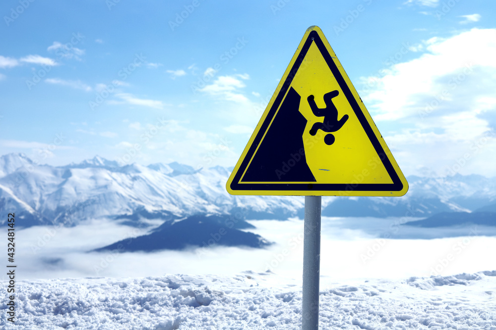 Warning sign of falling off cliff edge in the mountains, sunny Warning sign of falling off cliff edge in the mountains, sunny