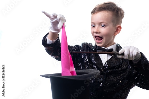 Magician kid illusionist boy in hat. suit trick isolated white background