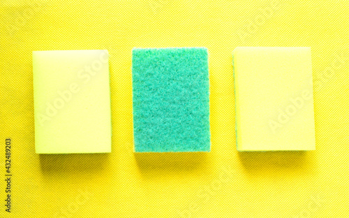 Three yellow sponges on yellow background.