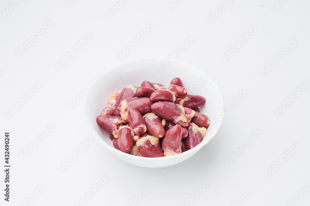 raw chicken hearts in a white plate on a white background. Close-up. raw chicken hearts in a white plate on a white background. Close-up.