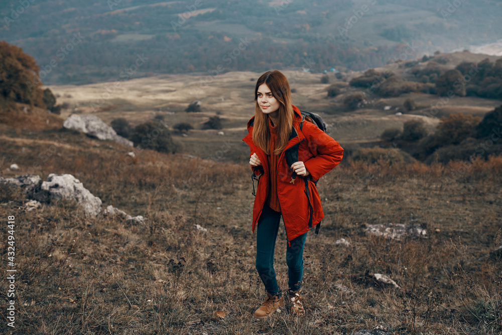 woman in a jacket with a backpack mountains steppe landscape autumn warm clothes model