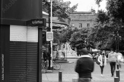 Wallpaper Mural 'Toilet' sign in park in Toulouse with a carousel and people walking in low shutter speed Torontodigital.ca