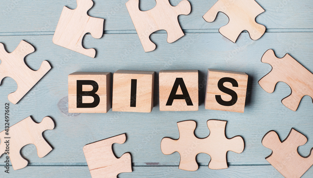 Obraz premium Blank puzzles and wooden cubes with the text BIAS lie on a light blue background.