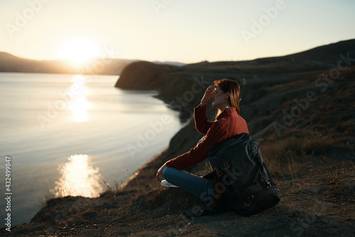 pretty woman tourist with backpack admiring the landscape sunset vacation