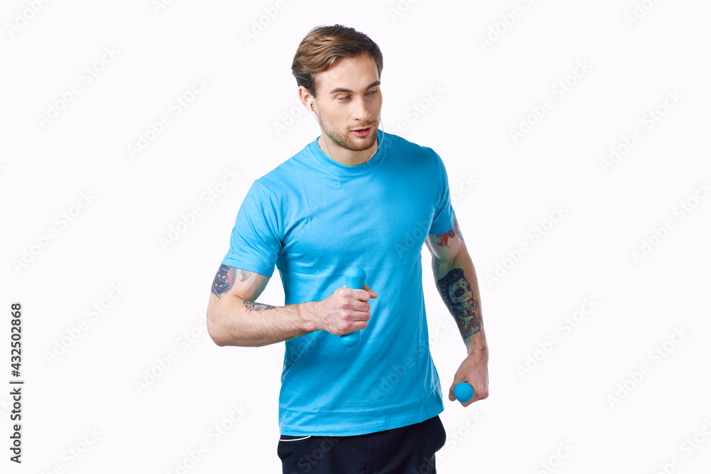 a man is engaged in fitness with dumbbells in his hands on a light background and a tattoo model a man is engaged in fitness with dumbbells in his hands on a light background and a tattoo model