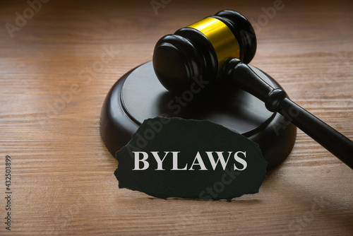 Bylaws phrase with gavel on wooden background. Business and law concept