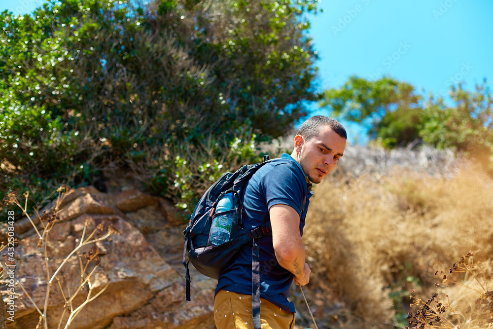 Weekend trekking. A guy with a backpack walks on the rocks. Active rest and enjoyment of nature Weekend trekking. A guy with a backpack walks on the rocks. Active rest and enjoyment of nature