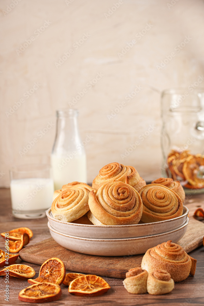Several cinnamon buns in a beige bowl on wooden board on wooden table Several cinnamon buns in a beige bowl on wooden board on wooden table