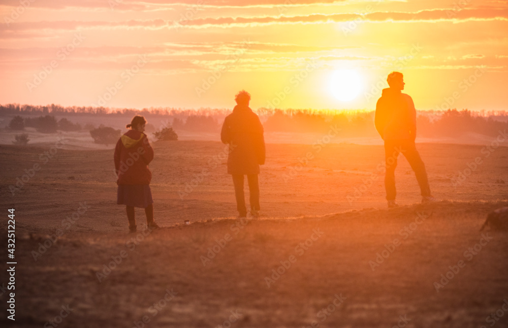 silhouettes of group of people in desert field on sunset silhouettes of group of people in desert field on sunset