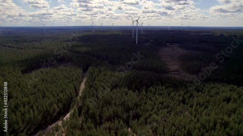 Dense Boreal Forest and Wind Power Turbine Farm, Renewable Energy Concept, Aerial Circling photo