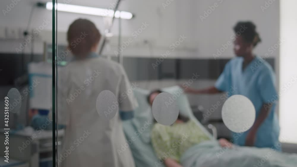 Sick woman resting in bed with oxygen tube explaining disease symptom to practitioner doctor while writing sickness treatment on clipboard. Black nurse putting oximeter examining recovery Sick woman resting in bed with oxygen tube explaining disease symptom to practitioner doctor while writing sickness treatment on clipboard. Black nurse putting oximeter examining recovery