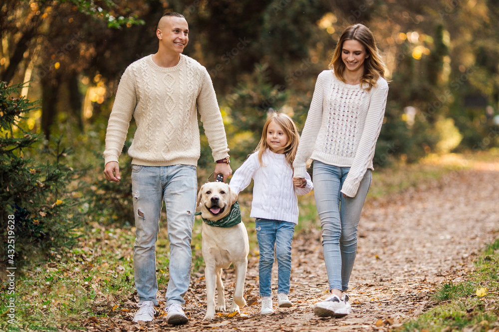 Fototapeta premium Happy family is having fun with dog labrador outdoors.
