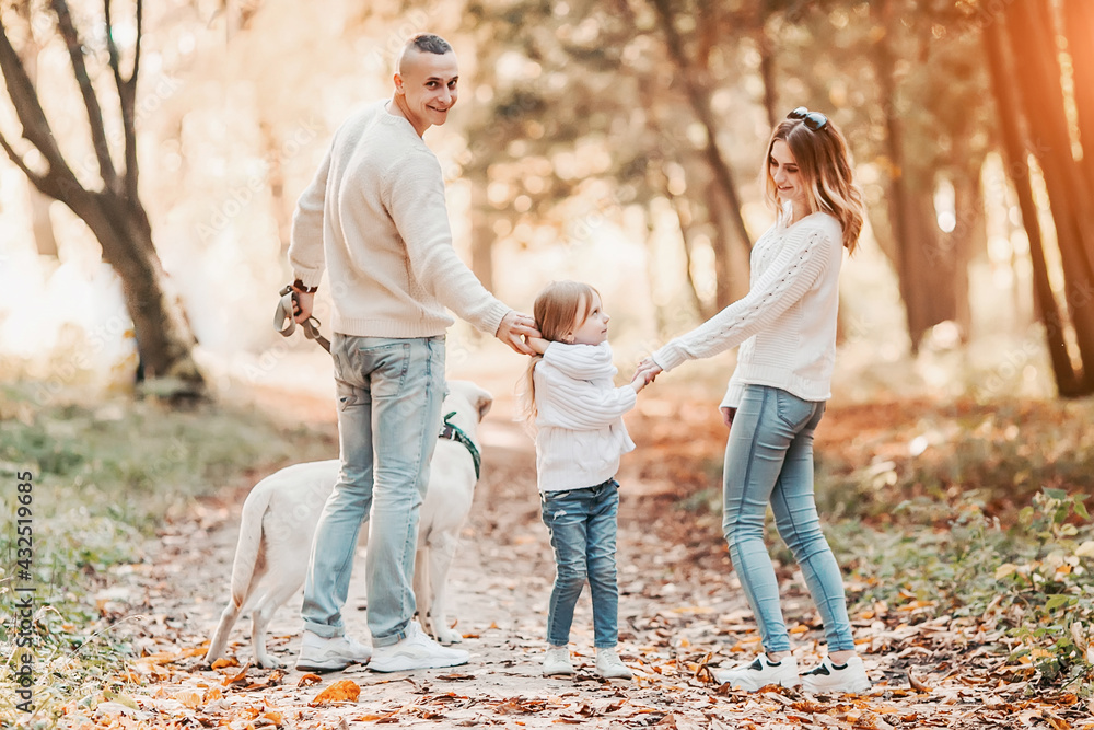 Happy beautiful family with dog labrador is having fun together walking the in park. Happy beautiful family with dog labrador is having fun together walking the in park.