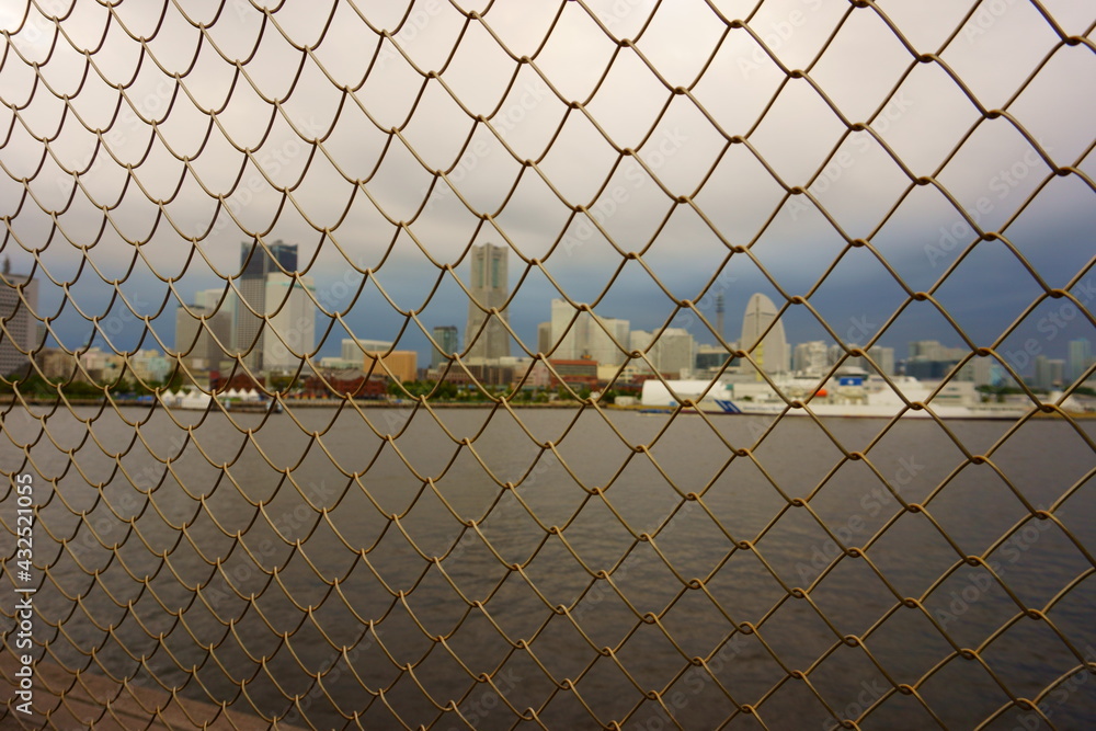 Kanagawa Prefecture Japan. View through netting. Thunderous cloudy sky over city Kanagawa Prefecture Japan. View through netting. Thunderous cloudy sky over city