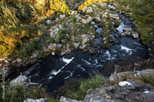 Abstract top view of a flowing river with slow shutter, water cascading through rapids in the gorge or creek of a river bed