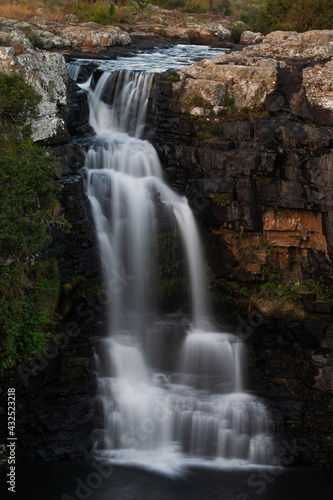 Fototapeta Naklejka Na Ścianę i Meble -  Beautiful slow shutter waterfall in Nelspruit South Africa, Water Cascading down a mountain side over the rocky terrain