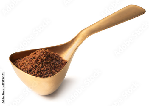 brown sugar in the measuring spoon, isolated on white background
