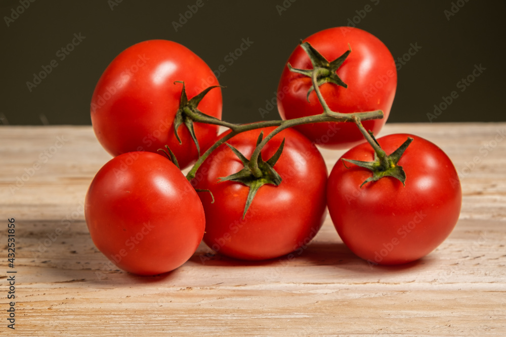 Juicy tomatoes on a wood background. Fresh vegetables on a branch. Kitchen. background for restaurant. Juicy tomatoes on a wood background. Fresh vegetables on a branch. Kitchen. background for restaurant.