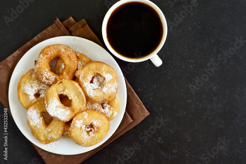 Homemade donuts on white plate, cup of black coffee