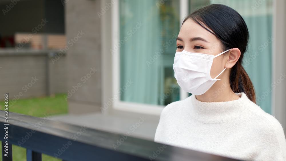 Young asian attractive beautiful woman wear face mask in front of house talk smile positive with copy space social distance in covid coronavirus at home. Conversation in person at safe distance. Young asian attractive beautiful woman wear face mask in front of house talk smile positive with copy space social distance in covid coronavirus at home. Conversation in person at safe distance.
