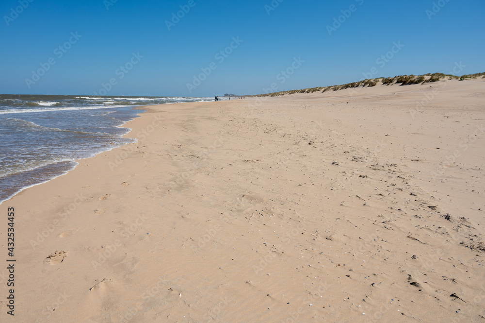 Yellow sandy beach in small Belgian town De Haan or Le Coq sur mer, luxury vacation destination, summer holidays
