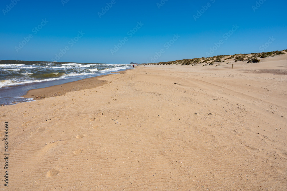 Yellow sandy beach in small Belgian town De Haan or Le Coq sur mer, luxury vacation destination, summer holidays Yellow sandy beach in small Belgian town De Haan or Le Coq sur mer, luxury vacation destination, summer holidays