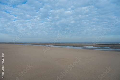 Low tide period on yellow sandy beach in small Belgian town De Haan or Le Coq sur mer  luxury vacation destination  summer holidays