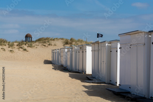 White beach huts on yellow sandy beach in small Belgian town Knokke-Heist, luxury vacation destination, summer holidays