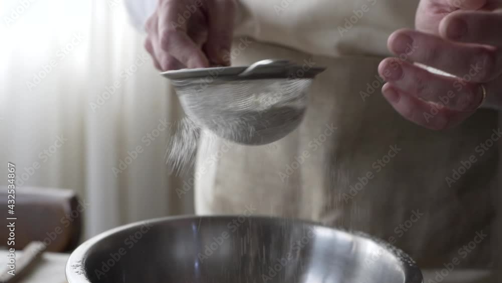 young woman sifting flour through a sieve young woman sifting flour through a sieve