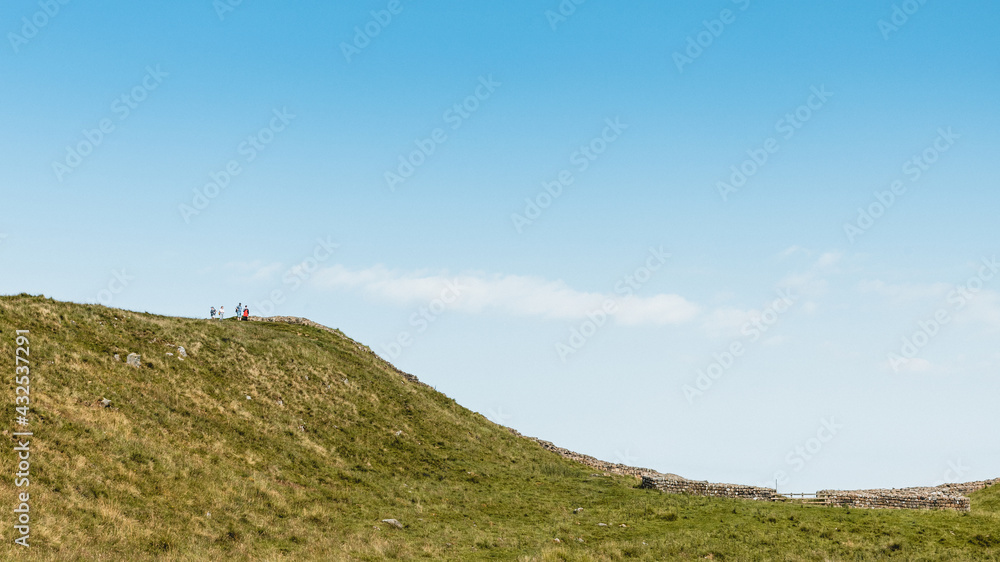 Northumberland UK: Hadrians Wall built on tall cliffs (Roman Wall) on a sunny summer day in English countryside Northumberland UK: Hadrians Wall built on tall cliffs (Roman Wall) on a sunny summer day in English countryside