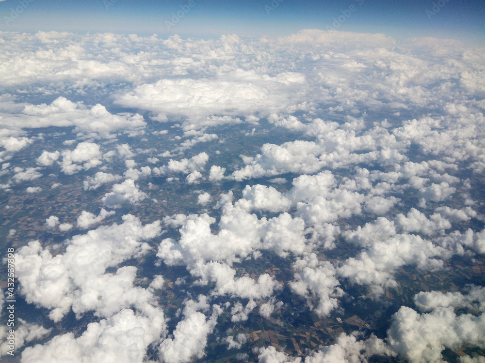 Fluffy clouds over the sky. Scenic view from the airplane window. Natural beauty of blue sky with clouds. Wing of the plane. Airplane flying in the sky. Fluffy clouds over the sky. Scenic view from the airplane window. Natural beauty of blue sky with clouds. Wing of the plane. Airplane flying in the sky.