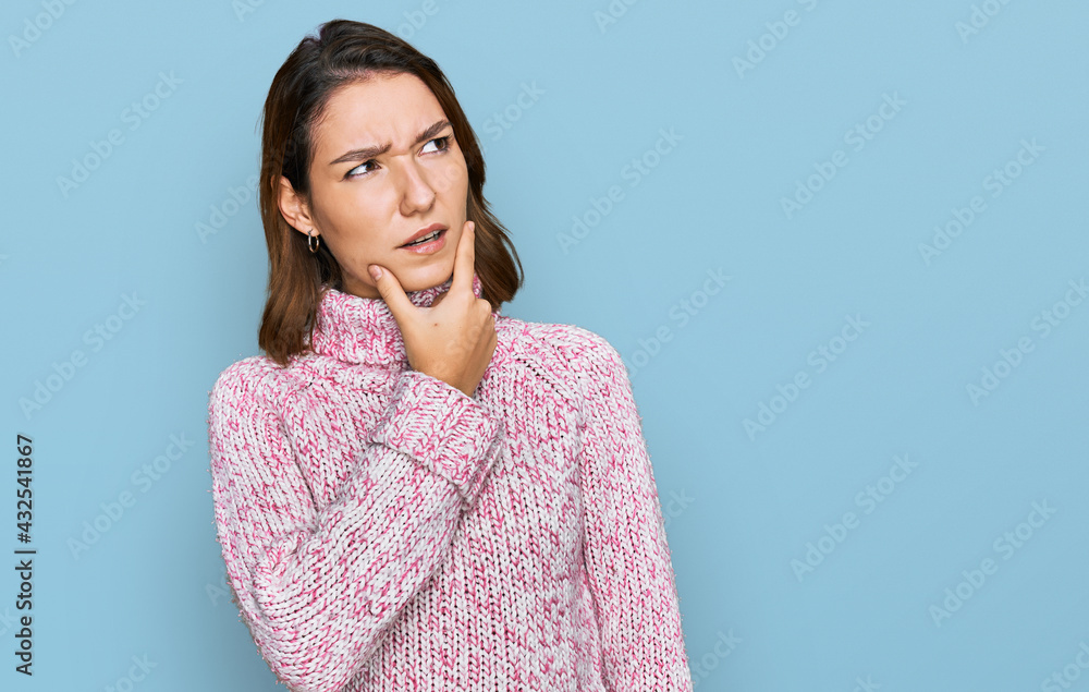 Young caucasian girl wearing wool winter sweater thinking worried about a question, concerned and nervous with hand on chin Young caucasian girl wearing wool winter sweater thinking worried about a question, concerned and nervous with hand on chin