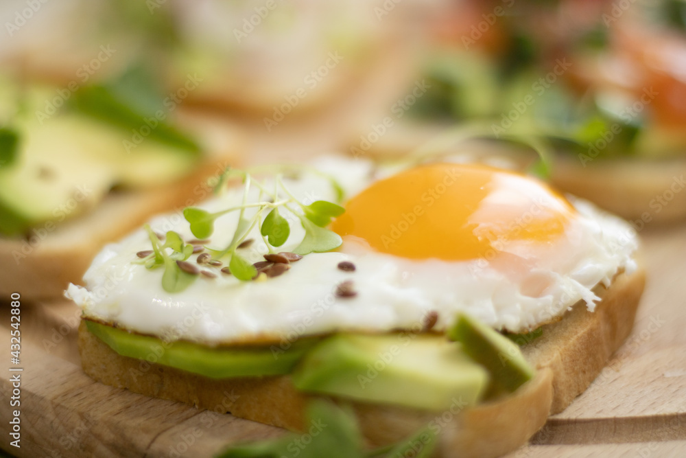 Fried Egg Avocado Sandwich - Sliced avocado and egg on toasted bread with arugula for a healthy breakfast or snack. Fried Egg Avocado Sandwich - Sliced avocado and egg on toasted bread with arugula for a healthy breakfast or snack.