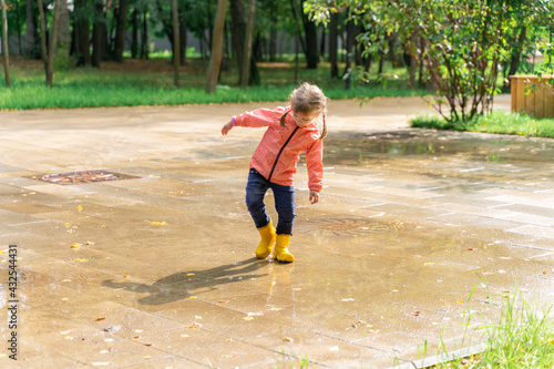 child jumping and playing in a puddle after rain © Елена Гурова