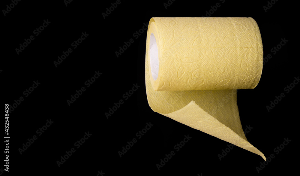 Obraz premium Roll of yellow toilet paper on black background close up
