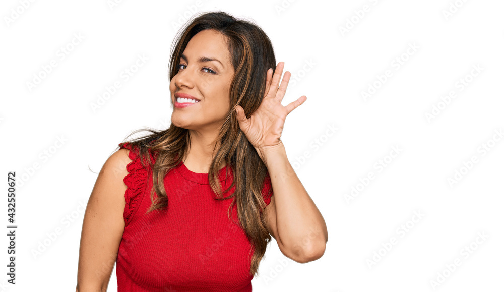Young hispanic woman wearing casual clothes smiling with hand over ear listening an hearing to rumor or gossip. deafness concept. Young hispanic woman wearing casual clothes smiling with hand over ear listening an hearing to rumor or gossip. deafness concept.