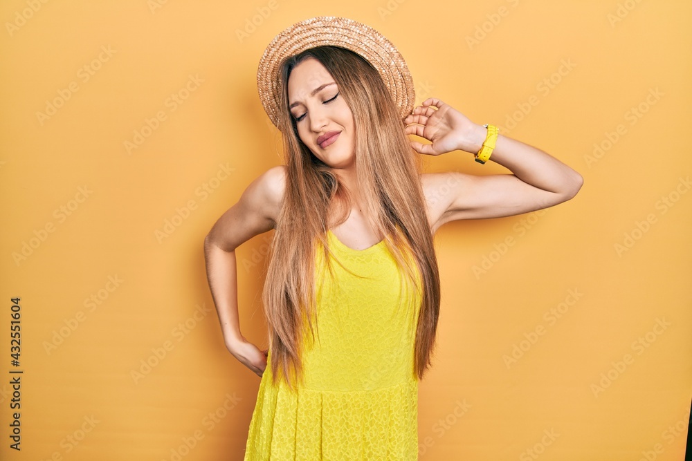 Young blonde girl wearing summer hat stretching back, tired and relaxed, sleepy and yawning for early morning Young blonde girl wearing summer hat stretching back, tired and relaxed, sleepy and yawning for early morning