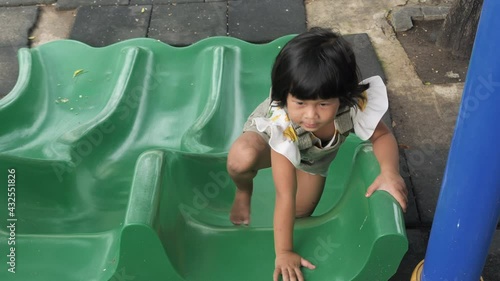 Child Girl play with slides and have fun at the playground.