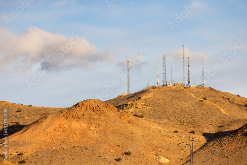 Obraz na plátne Golden morning light on a mountain topped by cell and communication towers