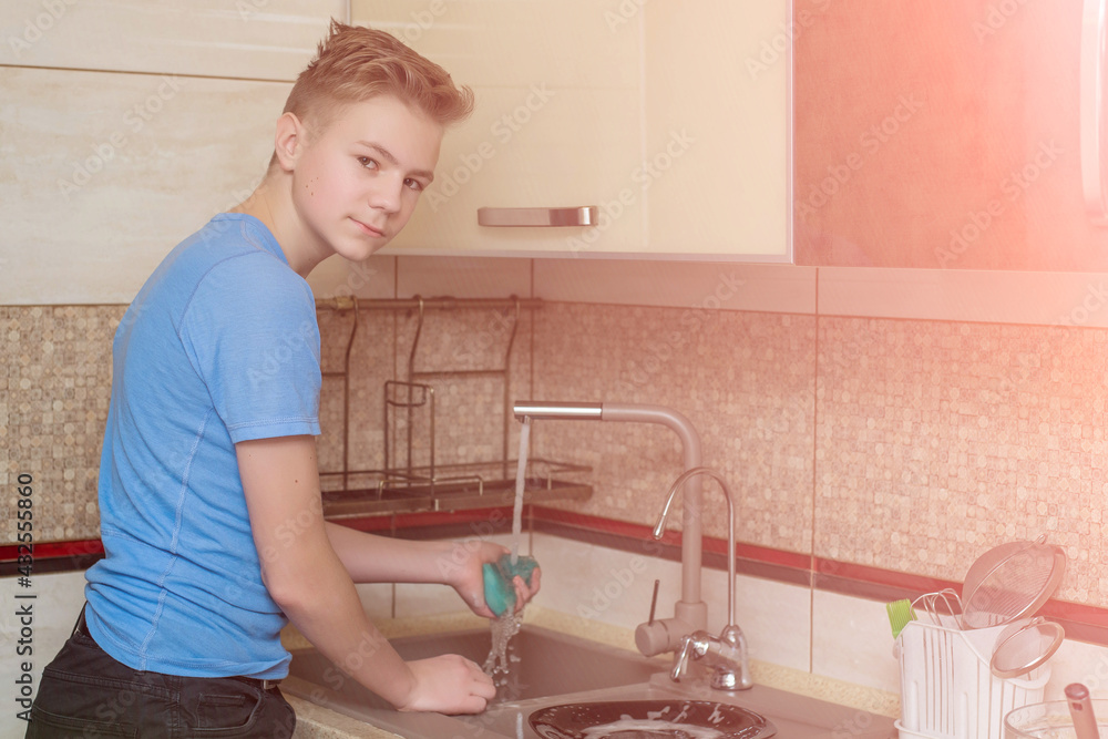 Boy doing the dishes in the sink Boy doing the dishes in the sink