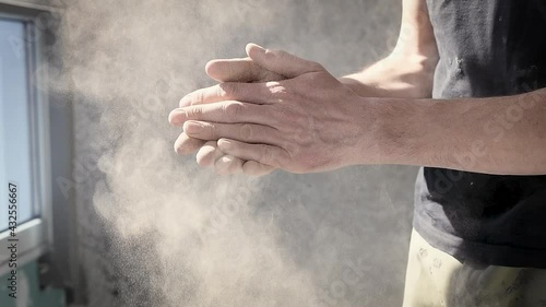 Worker claps his hands to dust off his hands after finishing work. Dirty and dusty work concept, allergen. Slow motion video
