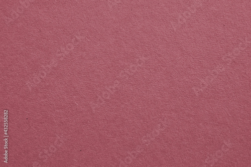 The surface of dark red cardboard. Paper texture with cellulose fibers. Purple-brown tinted background. Puce paperboard wallpaper. Beautiful textured backdrop. Top-down. Macro