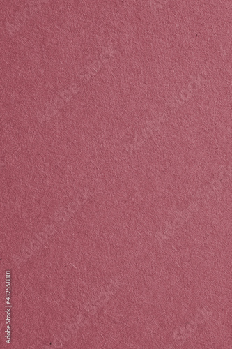 The surface of dark red cardboard. Paper texture with cellulose fibers. Vertical purple-brown tinted background. Puce paperboard wallpaper. Beautiful textured backdrop. Top-down. Macro