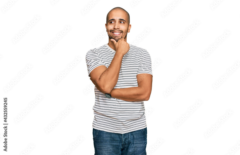 Hispanic adult man wearing casual clothes with hand on chin thinking about question, pensive expression. smiling with thoughtful face. doubt concept. Hispanic adult man wearing casual clothes with hand on chin thinking about question, pensive expression. smiling with thoughtful face. doubt concept.