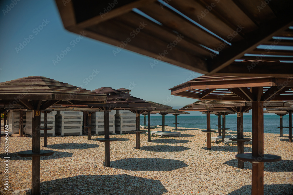 Wooden beach umbrellas by the sea in clear weather